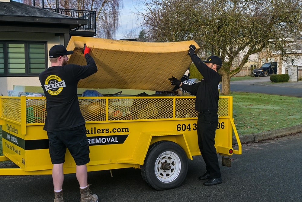 Tidy Trailers staff moving a mattress